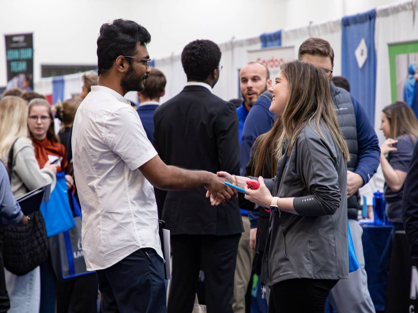 Two people shaking hands at a career fair